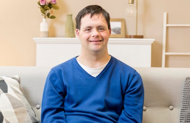Man smiling warmly while relaxing at home